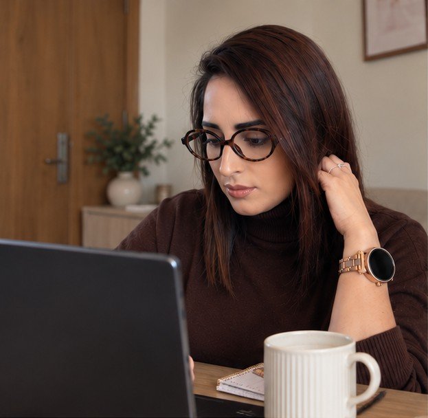 Farkhana working at her laptop with a coffee